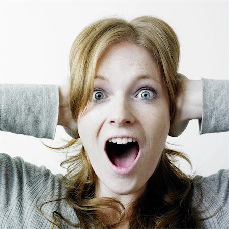 Woman covering ears and looking as if she is screaming; perhaps avoiding hearing something Stock Photo - Budget Royalty-Free & Subscription, Code: 400-03986216