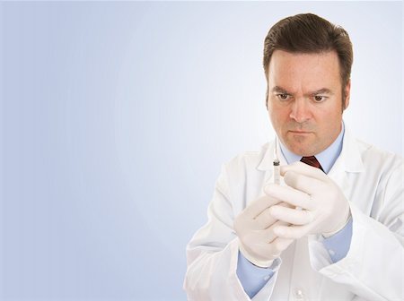 Doctor preparing a syringe to give a shot.  Blue background with room for text. Stock Photo - Budget Royalty-Free & Subscription, Code: 400-03986438