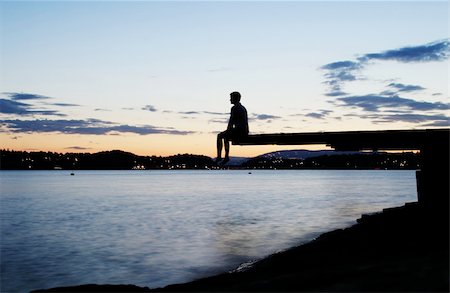 A young person sitting on a dock at dusk, at the fjord in Oslo, Norway Stock Photo - Budget Royalty-Free & Subscription, Code: 400-03987570