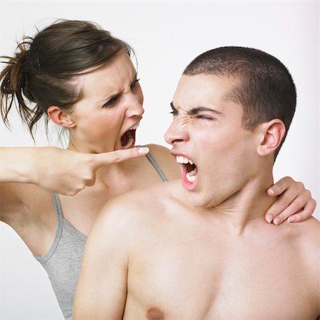 A young couple turn to face each other, yelling at each other. The woman is pointing at the young man. Stock Photo - Budget Royalty-Free & Subscription, Code: 400-03987762