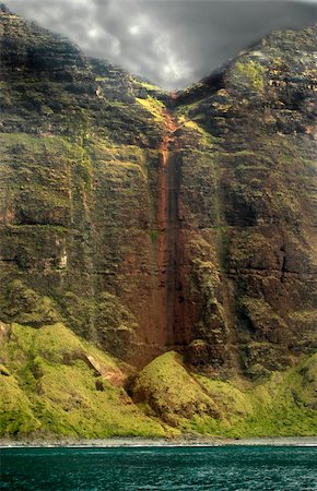 Grey clouds form over Na Pali Coastline.  Old waterfall has changed course and is no longer falling from this high cliffside.  Aqua waters. Photographie de stock - Aubaine LD & Abonnement, Code: 400-03988130