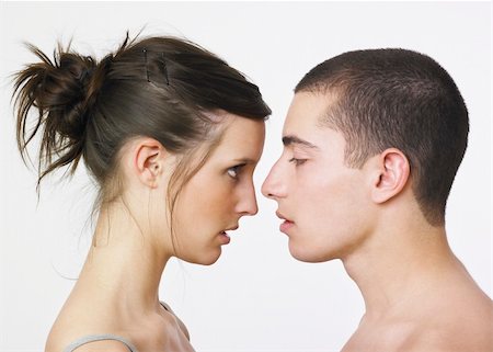 Young couple facing each other . Woman looking at man . Man eyes closed . White background. Stock Photo - Budget Royalty-Free & Subscription, Code: 400-03988422