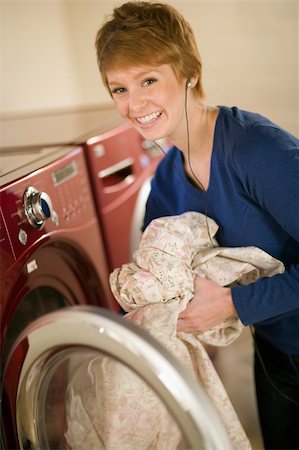 dry the bed sheets - Smiling woman with earphones taking laundry out of dryer Stock Photo - Budget Royalty-Free & Subscription, Code: 400-03989224