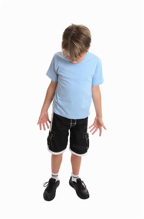 Boy standing in plain blue t-shirt and shorts looking down.  Focus to head. Stock Photo - Budget Royalty-Free & Subscription, Code: 400-03989336