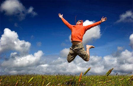 simsearch:400-06077546,k - Man jumping on a green meadow with a beautiful cloudy sky Stockbilder - Microstock & Abonnement, Bildnummer: 400-03989660