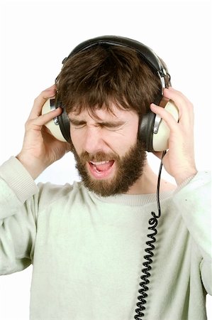 phone with pain - A man not enjoying what he is hearing, listening to music on large retro headphones.  Isolated on white with clipping path. Stock Photo - Budget Royalty-Free & Subscription, Code: 400-03983621
