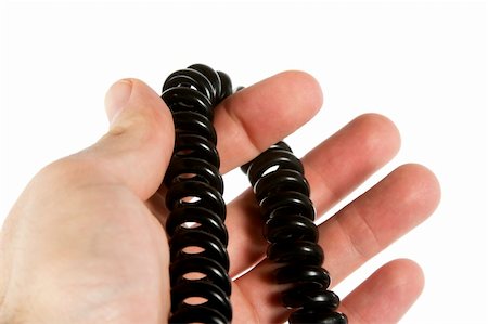 A coiled cord in the hand of a male over white. Stock Photo - Budget Royalty-Free & Subscription, Code: 400-03983652