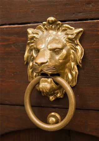 door lion - An old Czech door knocker in the form of a lion's head, worn shiny in places from being touched over the years. Stock Photo - Budget Royalty-Free & Subscription, Code: 400-03983669