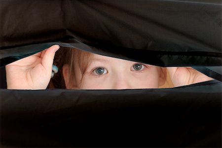 child face looking over the hole in a black matherial Stock Photo - Budget Royalty-Free & Subscription, Code: 400-03994579