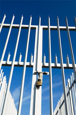 Modern spiked fence and gate closed with a padlock Stock Photo - Budget Royalty-Free & Subscription, Code: 400-03994868