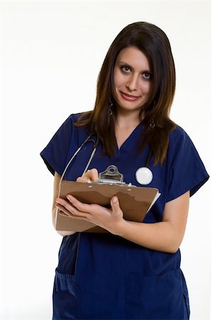 Woman healthcare worker in blue scrubs holding and writing on a patient chart standing on white looking up Fotografie stock - Microstock e Abbonamento, Codice: 400-03994898
