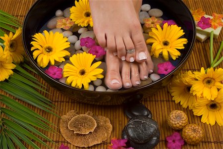 smelling feet - Spa treatment with aromatic gerbera daisies, healing stones, olive oil soaps and herbal water Stock Photo - Budget Royalty-Free & Subscription, Code: 400-03994966