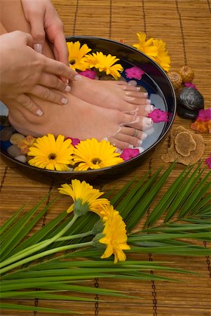 smelling feet - Spa treatment with aromatic gerbera daisies, healing stones, olive oil soaps and herbal water Stock Photo - Budget Royalty-Free & Subscription, Code: 400-03994963