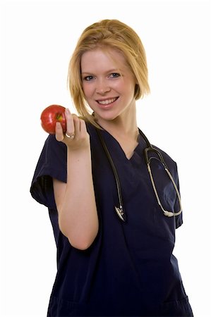 simsearch:400-03995908,k - Young pretty woman healthcare worker wearing blue scrubs and a stethoscope holding a red apple in her hand standing on white Stock Photo - Budget Royalty-Free & Subscription, Code: 400-03995403