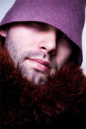 Portrait of young man wearing purple hat and fur, sparkle in the eye, eyes in shadow. Stock Photo - Budget Royalty-Free & Subscription, Code: 400-03995532