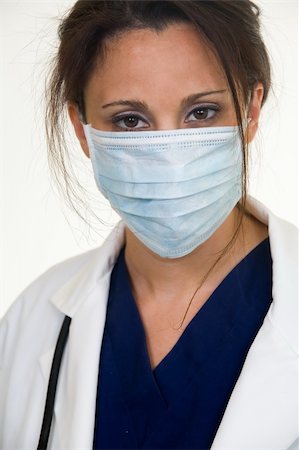 simsearch:400-05172792,k - Brunette lady doctor wearing white lab coat with a stethoscope around shoulders and a blue mask over face Foto de stock - Royalty-Free Super Valor e Assinatura, Número: 400-03995908