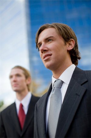 simsearch:400-04631810,k - two businessmen standing side by side looking forward in front of tall blue office building Stock Photo - Budget Royalty-Free & Subscription, Code: 400-03996310