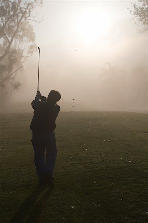 Early morning golfers silhouetted in a dense fog with a rising sun Foto de stock - Royalty-Free Super Valor e Assinatura, Número: 400-03997921