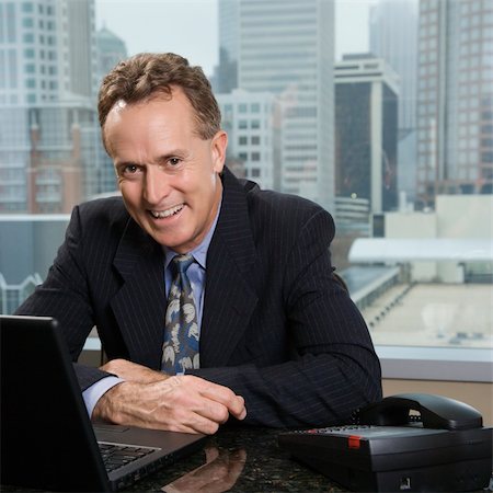 simsearch:400-04186486,k - Middle-aged Caucasian male in office with skyline in background. Stock Photo - Budget Royalty-Free & Subscription, Code: 400-03998256