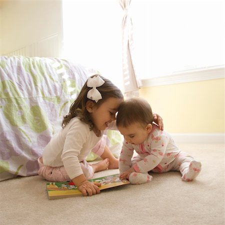 sister hugs baby - Caucasian girl children sitting on bedroom floor looking at book. Stock Photo - Budget Royalty-Free & Subscription, Code: 400-03998279