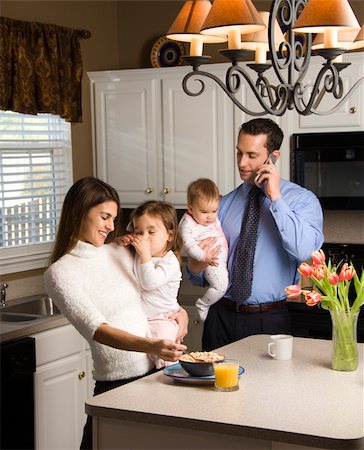 Caucasian mother and father in kitchen busy with children and cellphone. Stock Photo - Budget Royalty-Free & Subscription, Code: 400-03998291