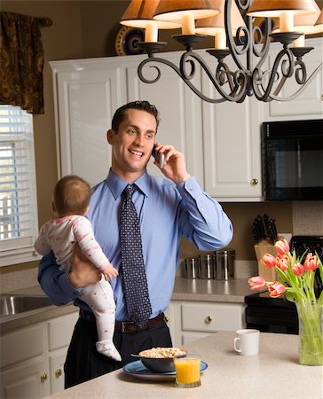 Caucasian father in suit holding baby  and talking on cellphone in kitchen. Stock Photo - Budget Royalty-Free & Subscription, Code: 400-03998292