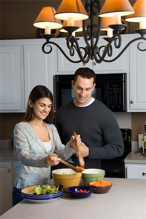 simsearch:400-04162443,k - Caucasian couple making salad at kitchen counter. Fotografie stock - Microstock e Abbonamento, Codice: 400-03998333