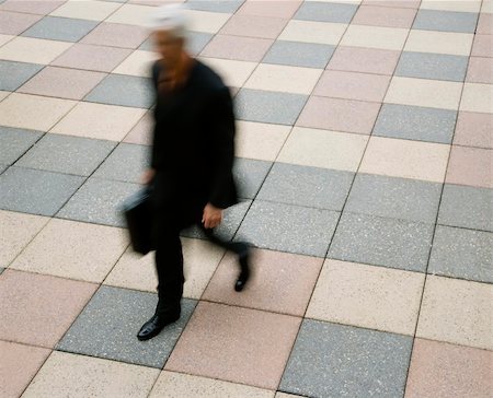 Motion blur of Caucasian businessman walking outdoors with briefcase. Stock Photo - Budget Royalty-Free & Subscription, Code: 400-03999326