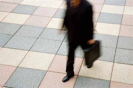 Motion blur of Caucasian businessman walking outdoors with briefcase. Stock Photo - Budget Royalty-Free & Subscription, Code: 400-03999327