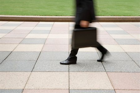 Motion blur of businessman legs walking outdoors with briefcase. Stock Photo - Budget Royalty-Free & Subscription, Code: 400-03999328