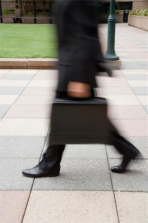 Motion blur of Caucasian businessman walking outdoors with briefcase. Stock Photo - Budget Royalty-Free & Subscription, Code: 400-03999329