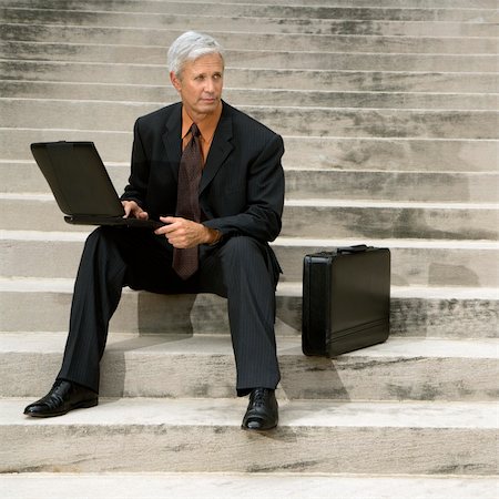 simsearch:400-04186486,k - Caucasian middle aged businessman sitting on steps outdoors with laptop and briefcase. Stock Photo - Budget Royalty-Free & Subscription, Code: 400-03999322