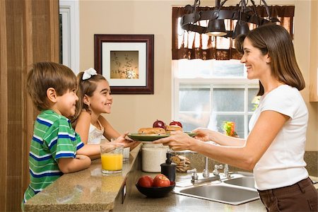 people eating bagels - Hispanic mother handing healthy breakfast to young children in home kitchen. Photographie de stock - Aubaine LD & Abonnement, Code: 400-03999344