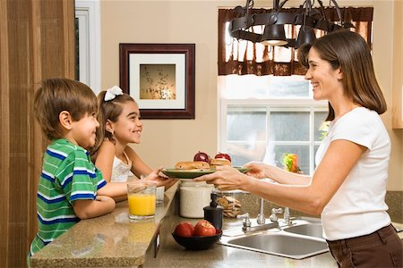 people eating bagels - Hispanic mother handing healthy breakfast to young children in home kitchen. Stock Photo - Budget Royalty-Free & Subscription, Code: 400-03999344