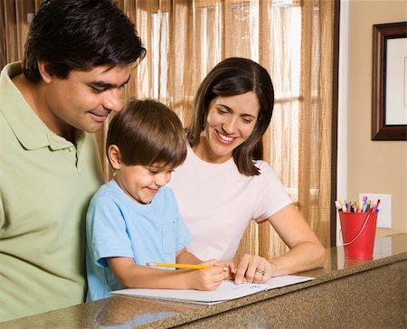 Hispanic parents helping son with homework. Foto de stock - Royalty-Free Super Valor e Assinatura, Número: 400-03999358