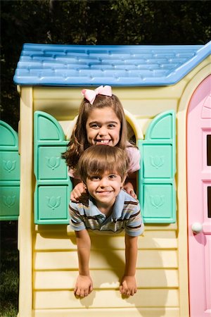 Hispanic boy and girl posing in window of playhouse and smiling at viewer. Stock Photo - Budget Royalty-Free & Subscription, Code: 400-03999380