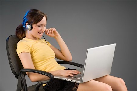 simsearch:400-03996848,k - pretty girl sitting with the laptop on her legs talking with microphone Fotografie stock - Microstock e Abbonamento, Codice: 400-03999695