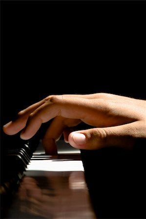 piano practice - A Caucasian maleís hand playing a piano in dramatic lighting Stock Photo - Budget Royalty-Free & Subscription, Code: 400-03990033