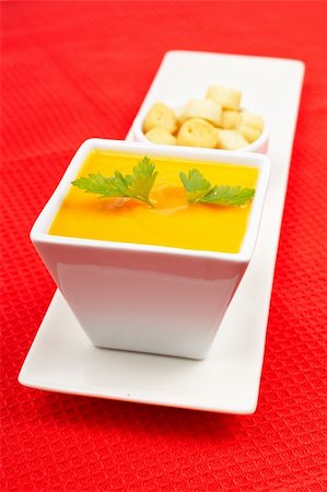 simsearch:400-07092695,k - Carrots puree and bread croutons on red mat. Shallow DOF Fotografie stock - Microstock e Abbonamento, Codice: 400-03991702