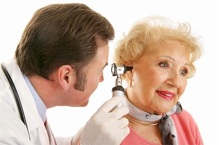 simsearch:400-04117274,k - Doctor using otoscope to look inside a beatiful senior woman's ears.  Isolated on white. Photographie de stock - Aubaine LD & Abonnement, Code: 400-03992440