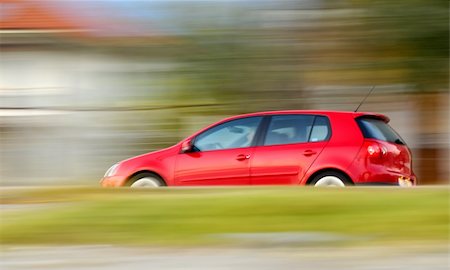 This is a panning shot of a fast moving red small car Stockbilder - Microstock & Abonnement, Bildnummer: 400-03992600
