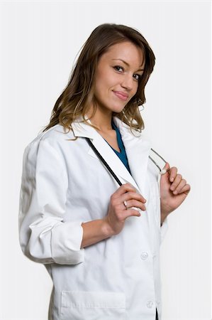 simsearch:400-03995908,k - Female brunette attractive doctor wearing white lab coat with a stethoscope around shoulders smiling standing Stock Photo - Budget Royalty-Free & Subscription, Code: 400-03993198
