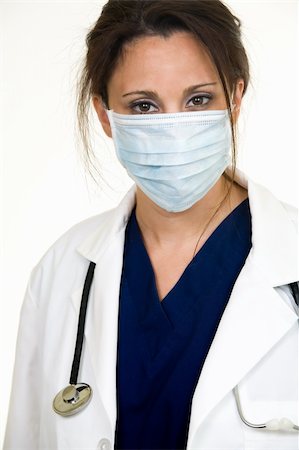 simsearch:400-03995908,k - Brunette lady doctor wearing white lab coat with a stethoscope around shoulders and a blue mask over face Stock Photo - Budget Royalty-Free & Subscription, Code: 400-03993388