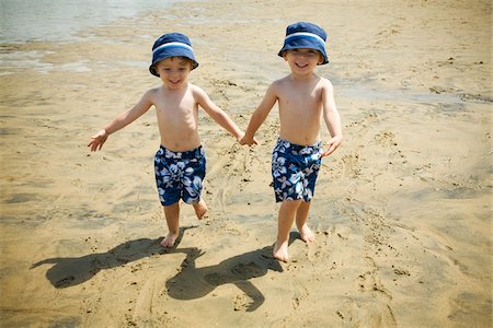 Twin Boys Walking Hand in Hand on Beach Foto de stock - Sin royalties Premium, Código: 600-04223560