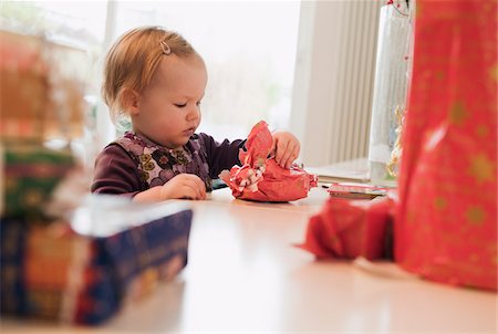 Baby Girl looking at Wrapped Christmas Gift Foto de stock - Sin royalties Premium, Código: 600-04425028