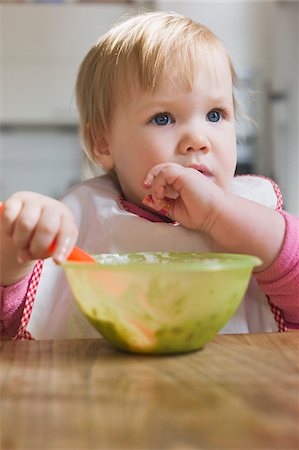 entranced - Baby Girl Eating from Bowl Foto de stock - Sin royalties Premium, Código: 600-04425161