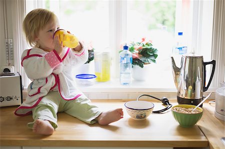 simsearch:600-05181882,k - Girl on Kitchen Counter Fotografie stock - Premium Royalty-Free, Codice: 600-04525181