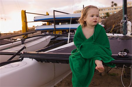 Portrait of Young Girl Wrapped in Towel Sitting on Mast of Sailboat Foto de stock - Sin royalties Premium, Código: 600-04926410