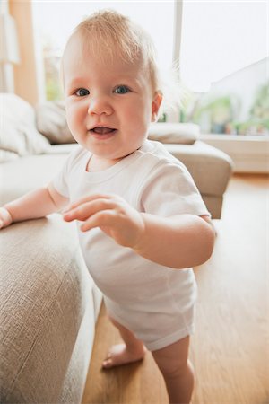 first steps baby - Baby Girl Standing by Sofa Foto de stock - Sin royalties Premium, Código: 600-05181885