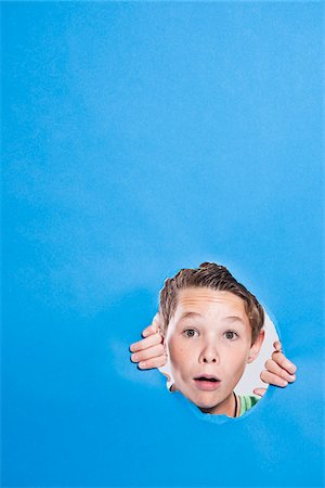 portrait of young and teenage boy - Boy Looking Through Hole Stock Photo - Premium Royalty-Free, Code: 600-05389105